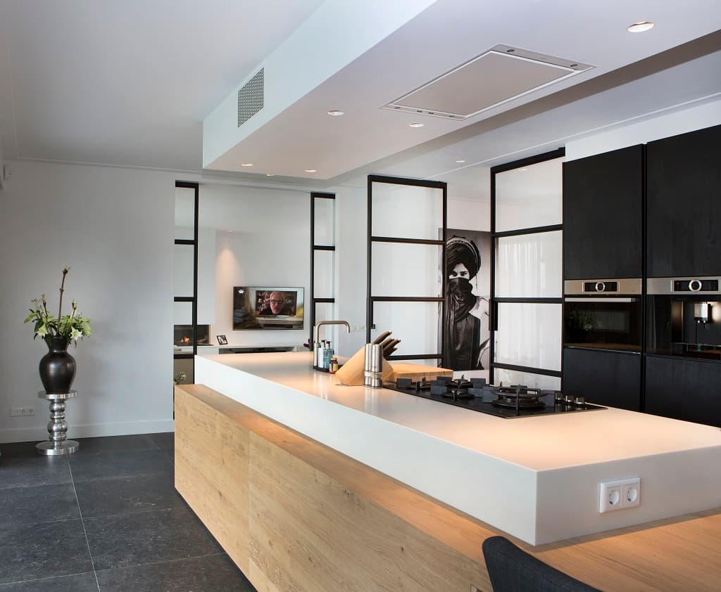 sliding steel glazed doors in a black finish used as a room divider between a kitchen and living room and entrance hall