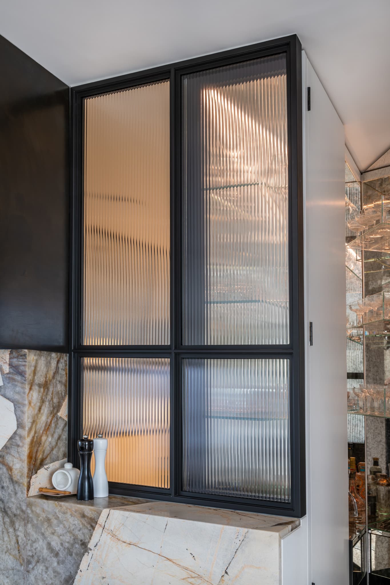 steel glazed fixed screen in black with fluted textured glass in a kitchen
