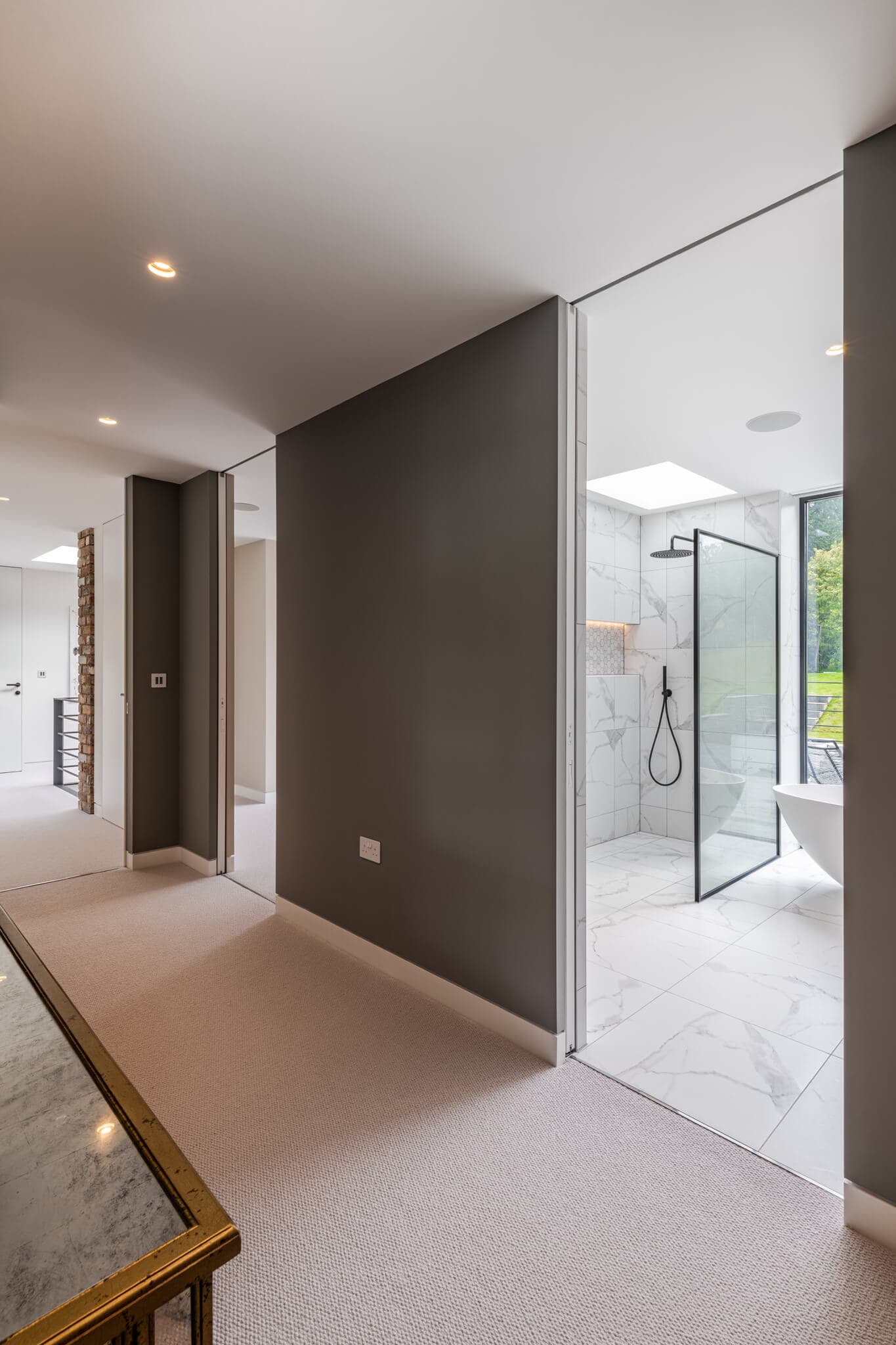 a wide sliding door leading to a white and black tiled bathroom.