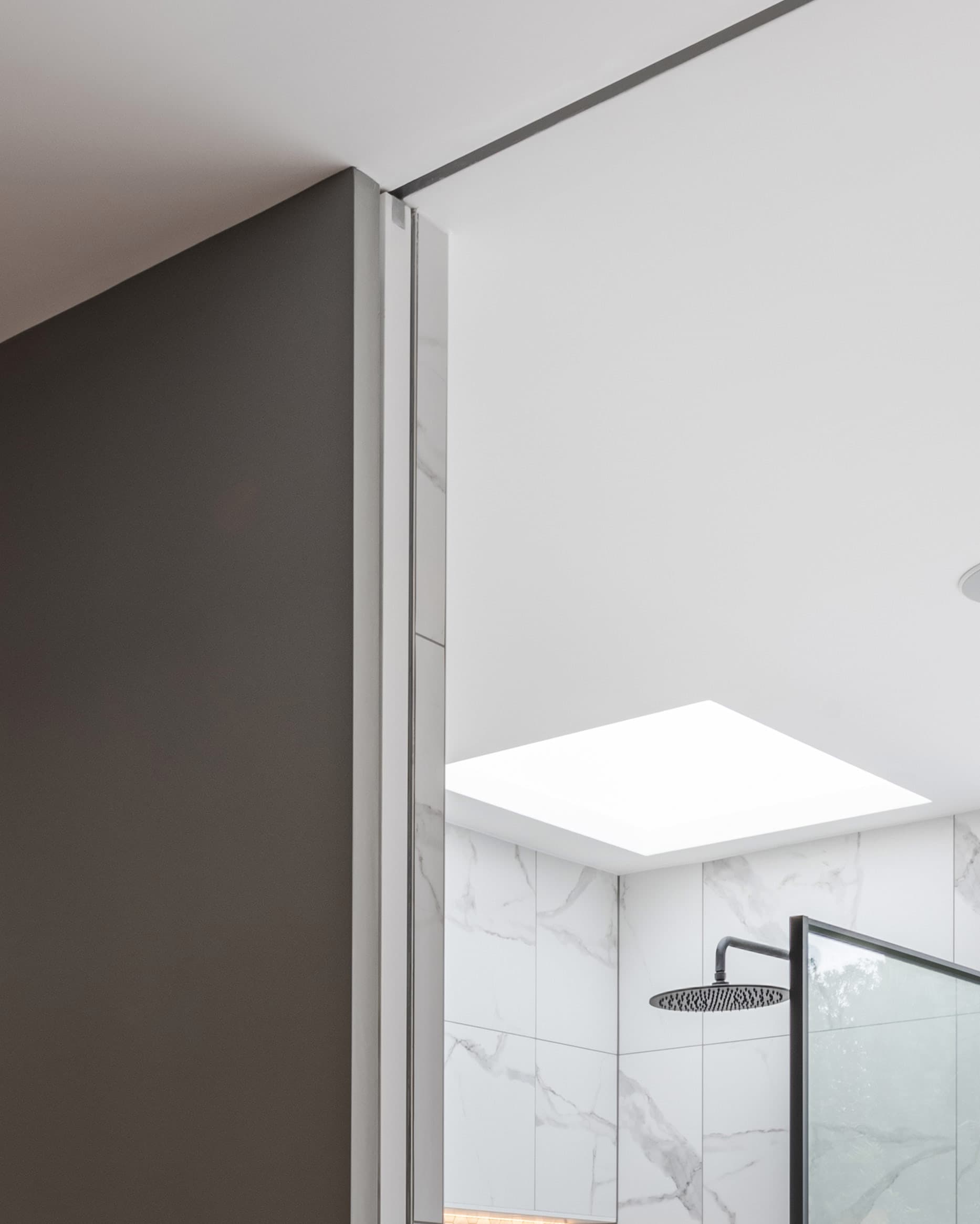 sliding pocket door in a bathroom showing split finishes including tiles