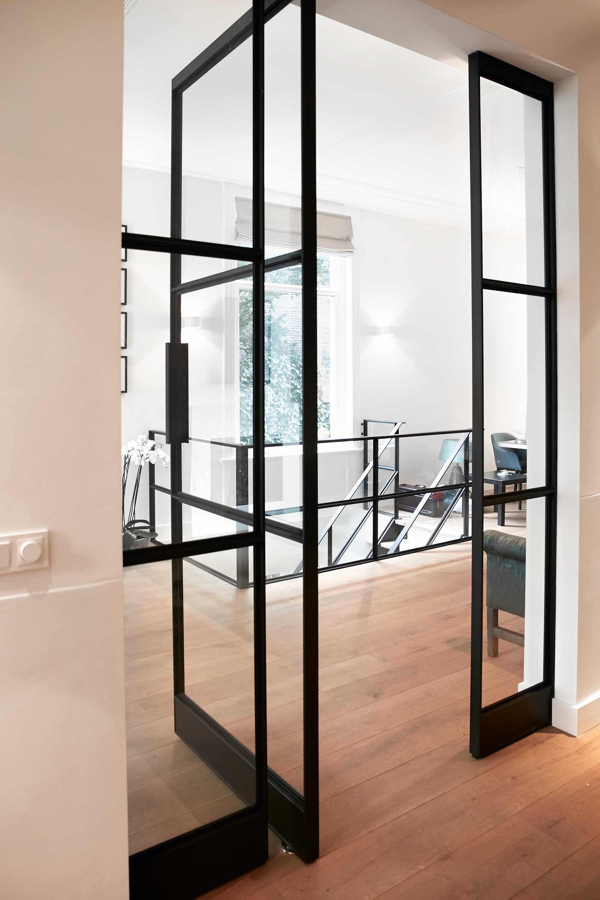 a wide opening angle is achieved by using a pivot hinge on this interior steel door in a black finish