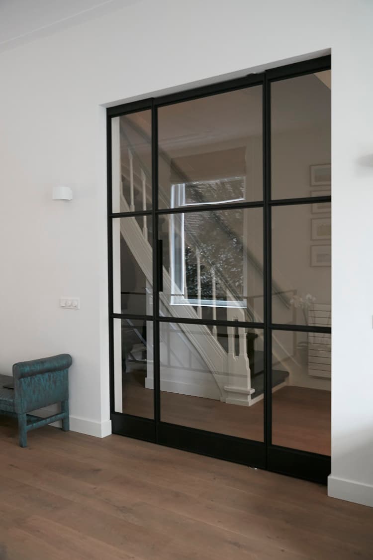 a single interior steel door seen with fixed steel-glazed panels either side