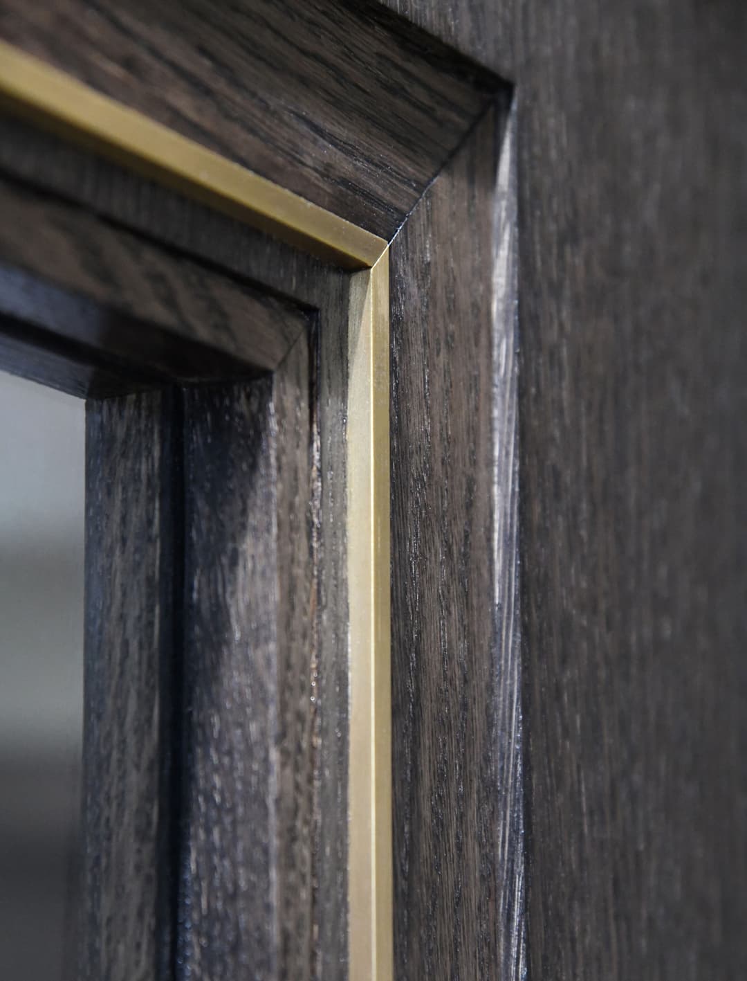 a timber door with metal inlay in brass and glazing